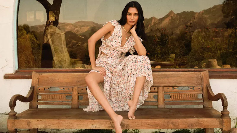 Woman sitting on top of a bench while wearing Free People clothing